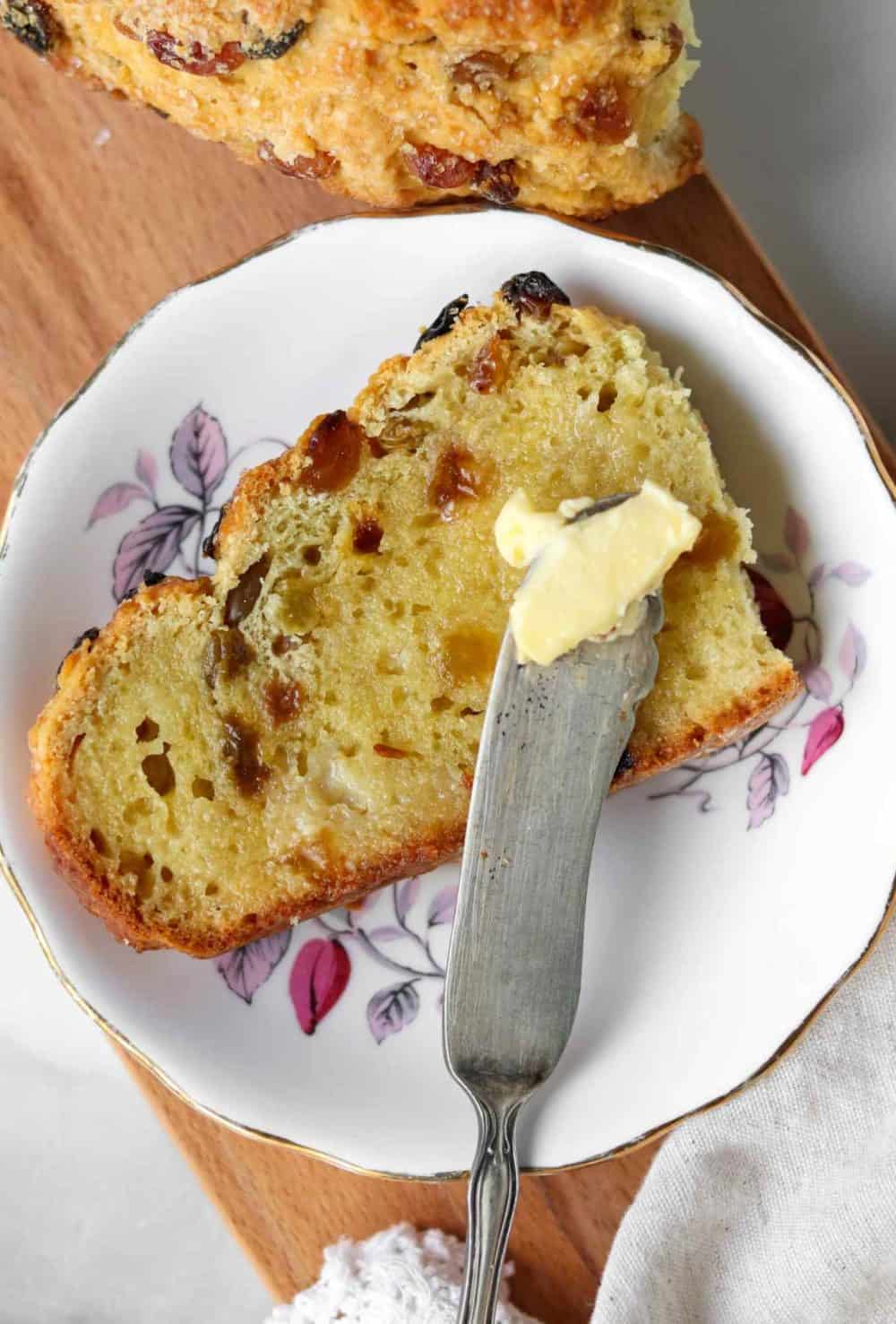 A warm slice of Irish soda bread, filled with whiskey-soaked raisins and glistening with salted Irish butter