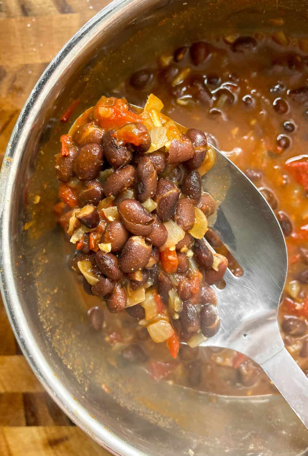 A pot of black beans simmered with tomatoes, onions and spices.
